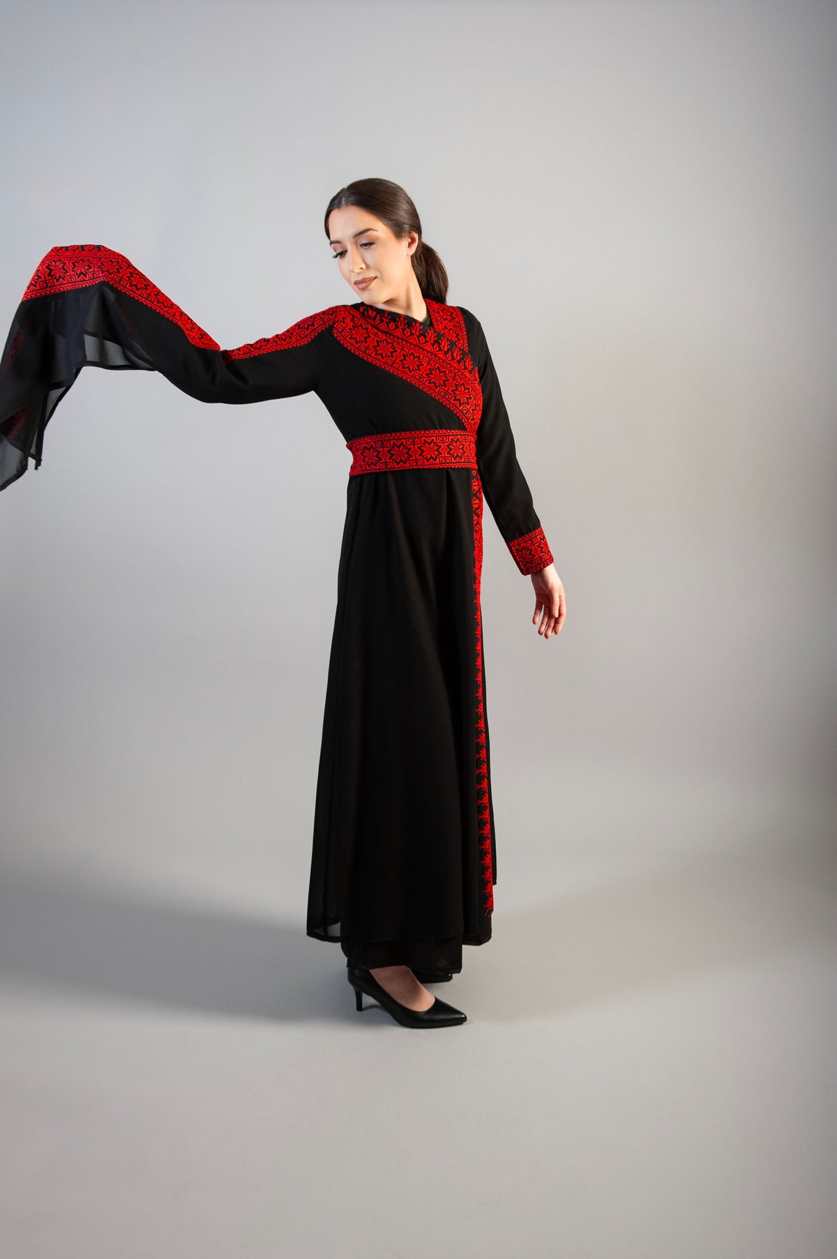 dress intricate embellishments, a gracefully wrapped waist belt, and a long sleeve for added refinement